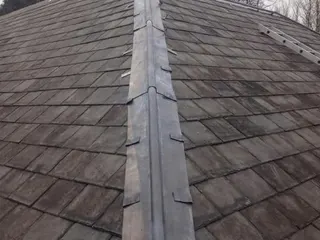 Lead ridge detail running along a pitched slate roof