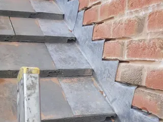 Stepped lead flashing where roofing meets brickwork